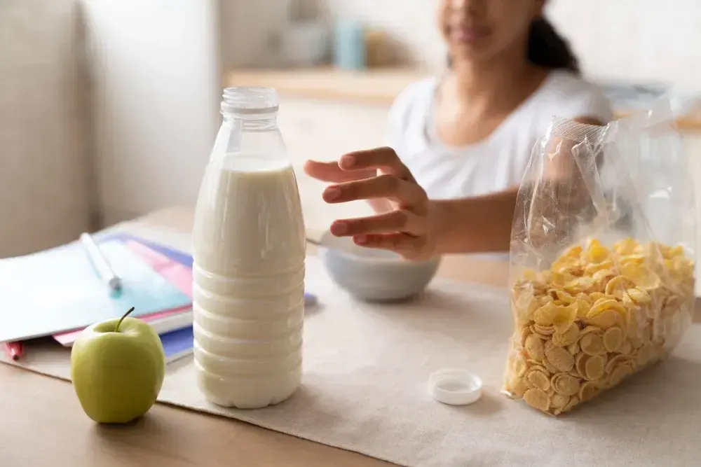 Mulher tem derivados de leite à sua frente. Ela tem intolrência à lactose.