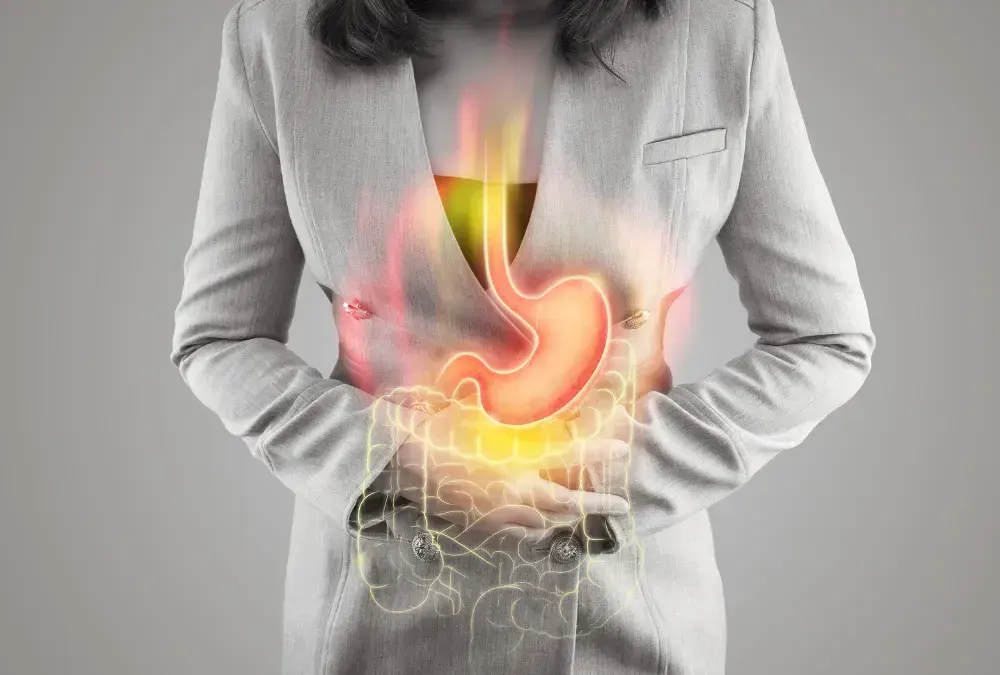 Mulher coloca as mãos na barriga com sintomas de refluxo-gastroesofagico