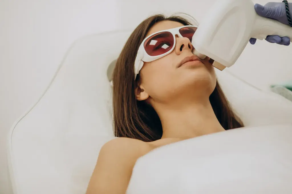 Mulher toca o rosto com acne durante o tratamento com laser.